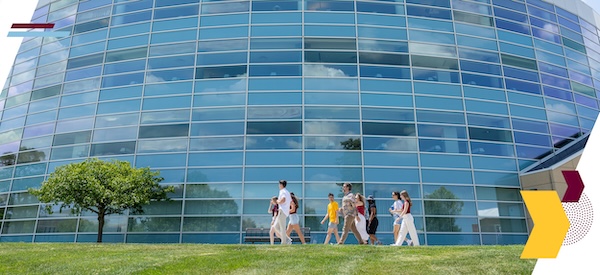 A group of students and family members walk past the exterior of Park Library.